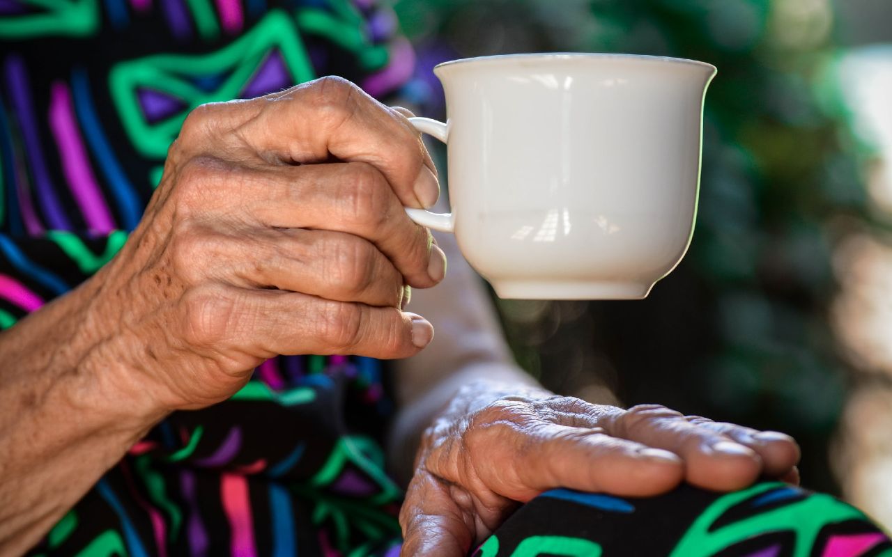 Closeup of an old woman holding a teacup illustrates the concept of end-of-life care