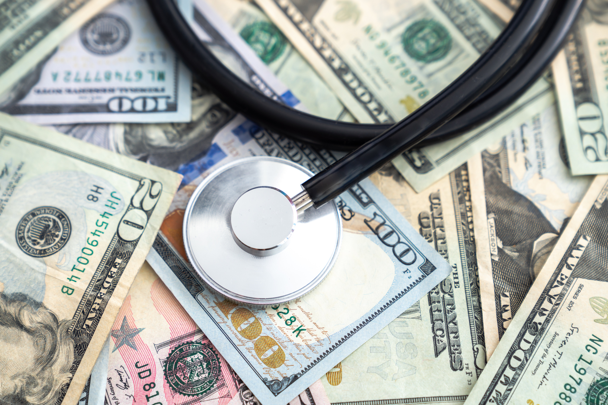 A stethoscope on a pile of money illustrates that rules around healthcare price transparency are meant to keep costs down